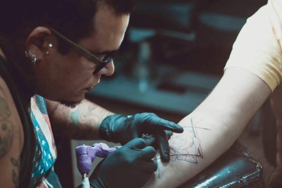 Tattoo artist sketching a custom tattoo design before tattooing a client